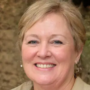 Close-up portrait of a smiling, middle-aged woman with short brown hair.